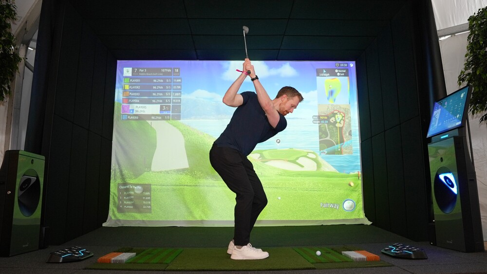 Man swinging an iron club on a TwoVisionNX simulator at the Pebble Beach Food and Wine Festival in 2025