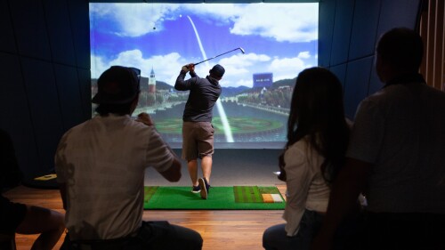 golfer post swing at sports bar with people watching