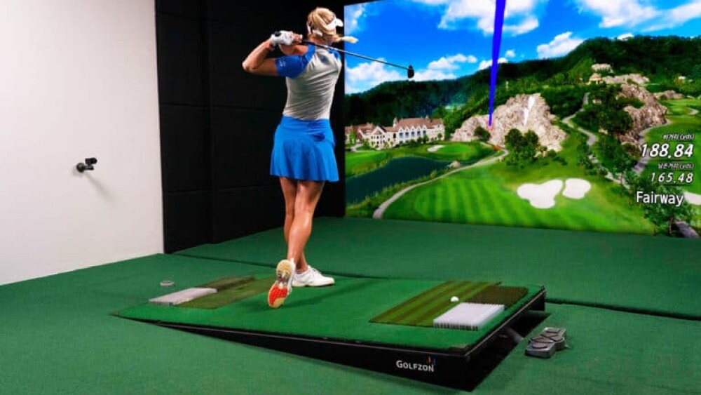 Female Swinging on Golfzon Golf Simulator Moving Swing Plate