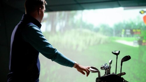 Golfer Looking At Screen With Hand on Golf Clubs in Golf Bag