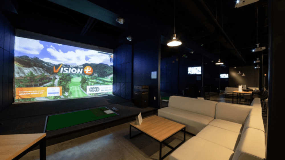BIRDI Golf Simulator Bay Setup Couches and Tables Behind Simulator
