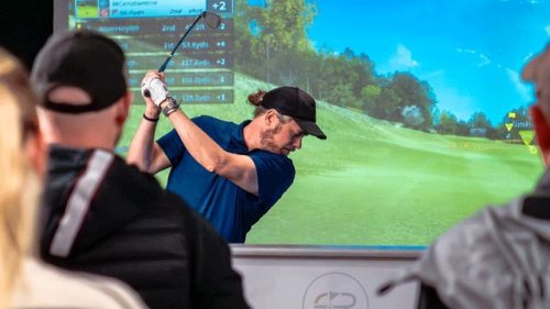 GOLFZON Tour - The Golf Rooms Golfer Swinging and Spectators Watching