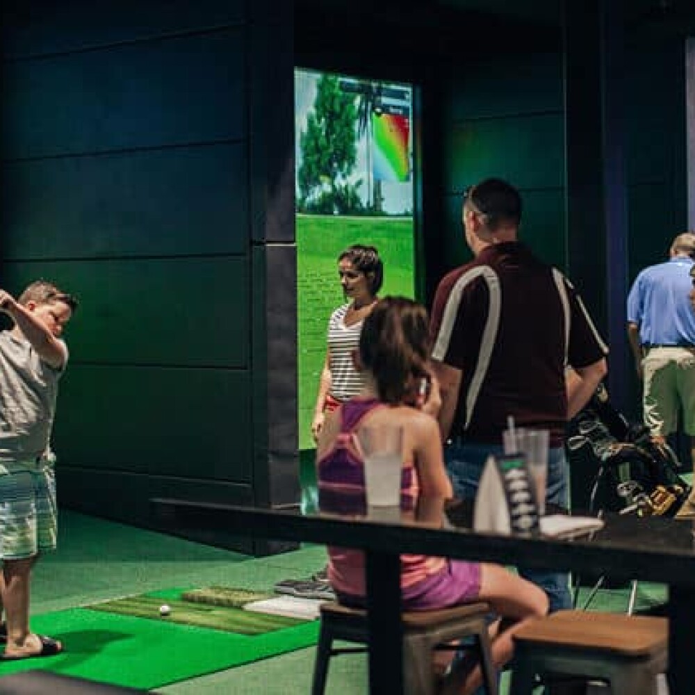 Kids Playing on Golfzon Golf Simulator in Busy Simulator Bar Space