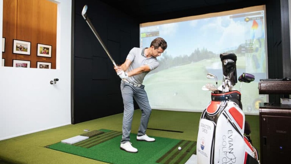 Male Golfer About to Swing on Golfzon Golf Simulator, Evian Golf Club Golf Bag Forefront Vision