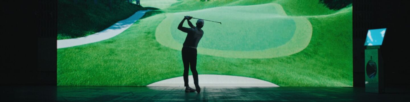GOLFZON Tour Promotional Image of Golfer Standing In Front of Golf Course on Screen