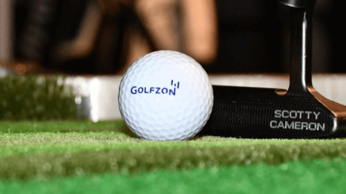 Golfzon Golf Ball with Scotty Cameron Putter Behind On Fairway Mat