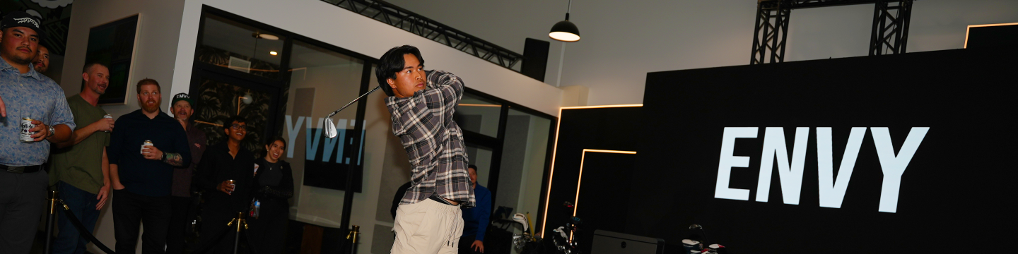 Young man swinging a golf club on the GOLFZON TwoVision Simulator