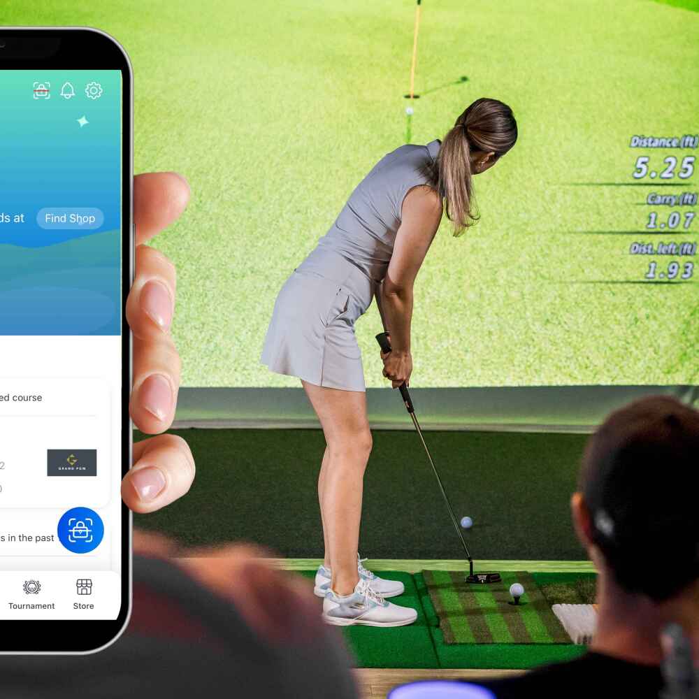 Golfzon Global App Shown on Phone, Person Holding Phone in Front of Golfzon TwoVision Simulator