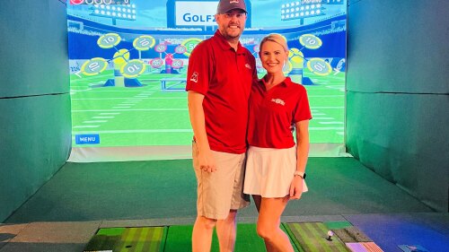 Laura Wilson and Her Husband at The 19th Hole in Boaz, Alabama - Posing in front of GOLFZON TwoVision simulator