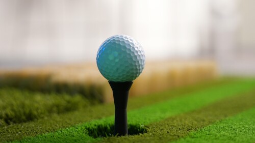 Golf ball sitting on an auto-tee