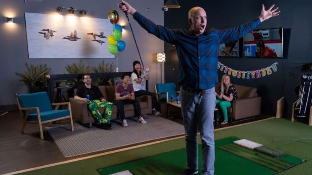 Guy Looking Excited At Golfzon Golf Simulator Screen On Moving Floor, Friends Cheering