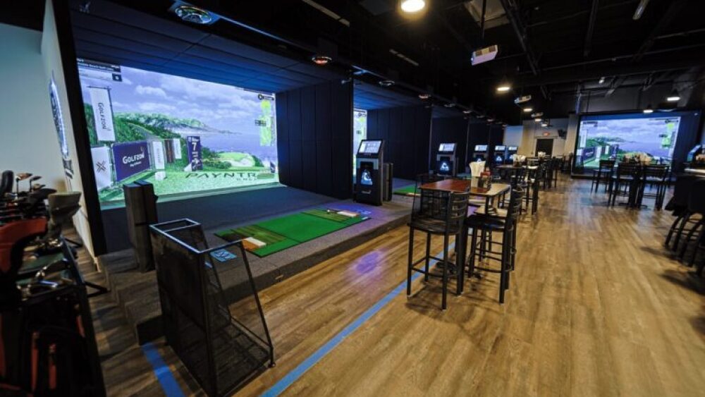 Golfzon TwoVision Commercial Setting with Multiple TwoVision Systems, Bar Stools and Tables, and Golf Clubs