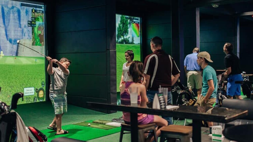 Kids Playing on Golfzon Golf Simulator in Busy Simulator Bar Space