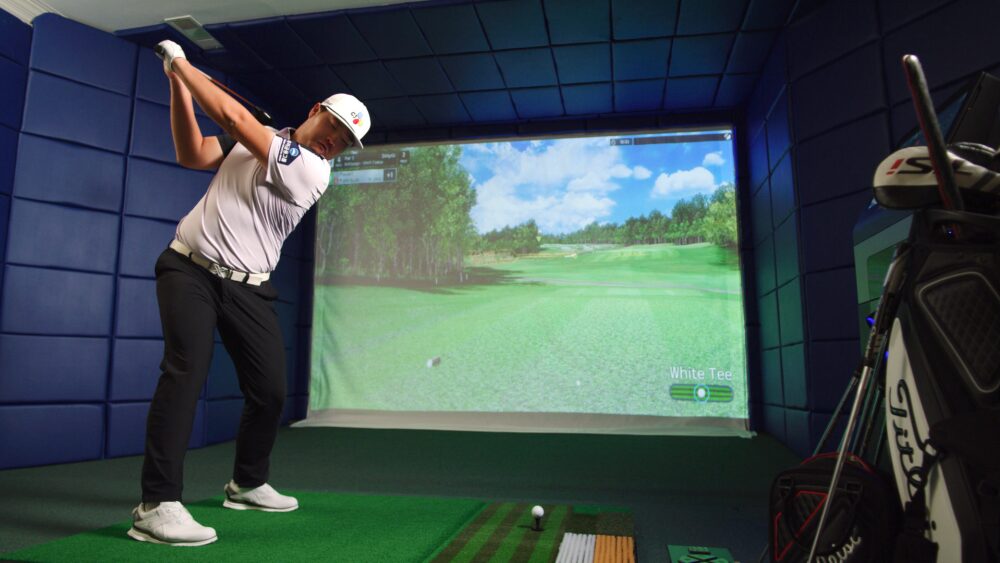 SJI Golfer Swinging Golf Club Playing on Golfzon Golf Simulator TwoVision