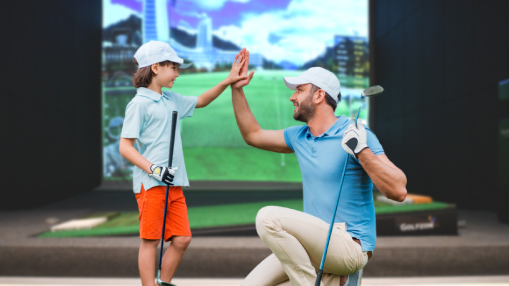 Kid golfer with instructor high-fiving